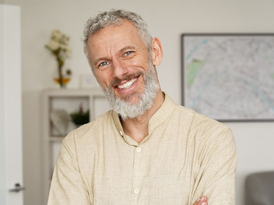 Middle-aged man in white button up smiling